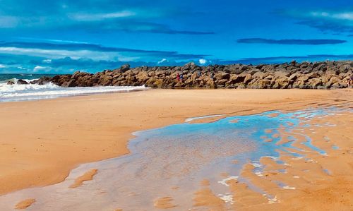 Scenic view of beach against blue sky