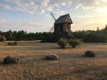 Traditional windmill on field against sky