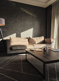 Coffee table with sunlight on empty sofa in luxury hotel