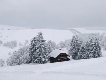 Wooden house covered in snow in the mountains during winter