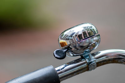 Chromed shiny bike bell with nice reflections of urban elements at a bike handlebar