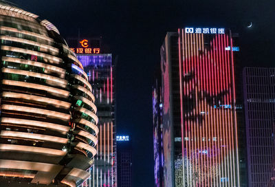 Low angle view of illuminated buildings against sky at night