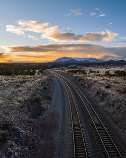 View of railroad tracks against sky during sunset