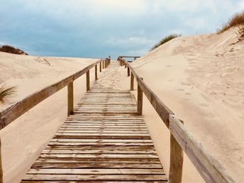 Boardwalk on beach against sky