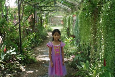 Portrait of a smiling girl standing against plants