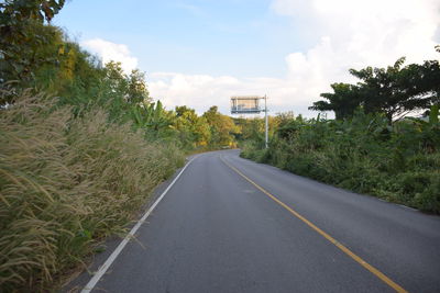 Road amidst trees against sky