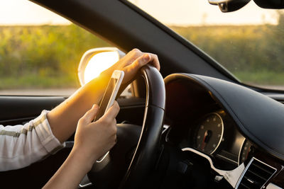 Cropped hand of man driving car