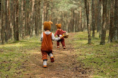 Rear view of boys running in forest