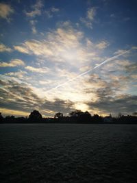 Scenic view of field against sky at sunset