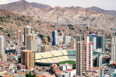 Stadium amidst buildings by mountains