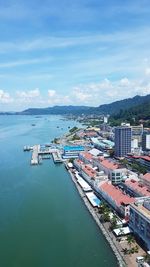 High angle view of buildings by sea against sky