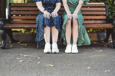 Female friends sitting on bench at park
