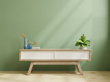 Modern wooden commode for tv mockup in empty room with green wall.3d rendering