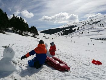 View of family on snow covered mountain