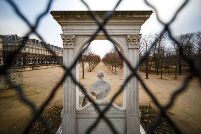 Rear view of woman seen through chainlink fence