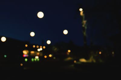 Defocused image of illuminated street lights in city at night