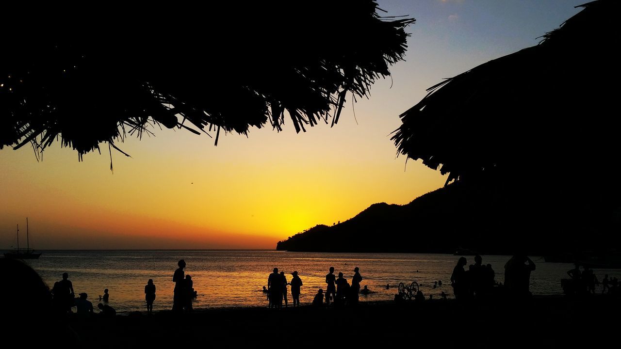 sea, sunset, water, silhouette, horizon over water, beach, scenics, beauty in nature, sky, large group of people, tranquil scene, tranquility, sun, vacations, shore, nature, orange color, idyllic, mountain