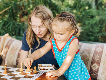 Father and daughter playing chess outdoors