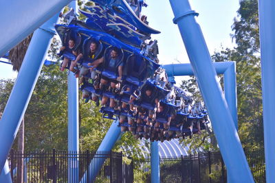 Low angle view of chain swing ride against blue sky