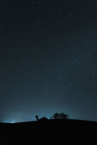 Low angle view of silhouette mountain against star field at night