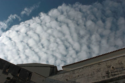 Low angle view of building against cloudy sky