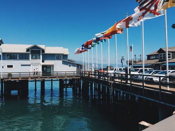 Pier over sea against clear blue sky