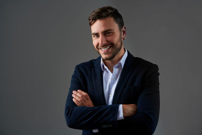 Portrait of smiling young man against black background