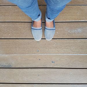 Low section of woman standing on hardwood floor