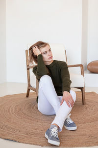 Side view of woman sitting on sofa at home