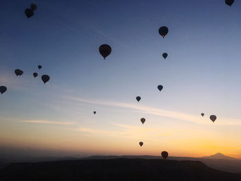 Low angle view of hot air balloons against sky during sunrise