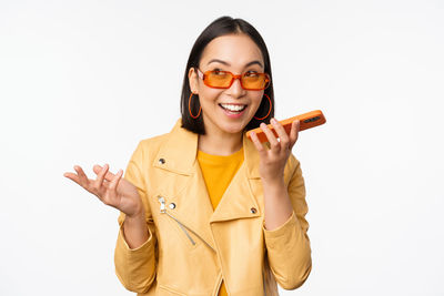 Young woman using mobile phone against white background