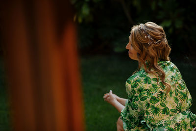 Midsection of woman standing against plants, bride waiting for her wedding dress 