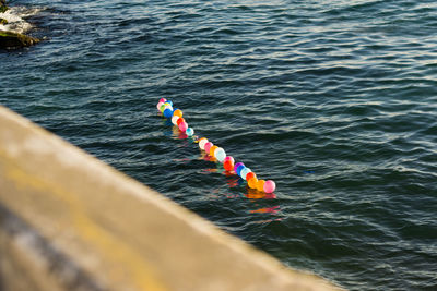 High angle view of multi colored balloons floating in sea