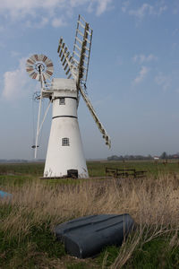 Traditional windmill on field against sky