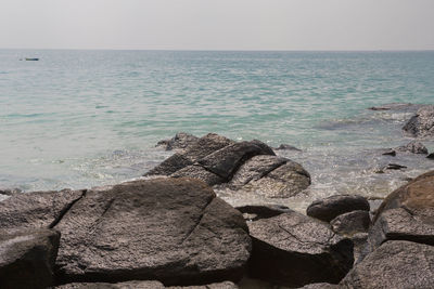 Rocks on sea shore against sky