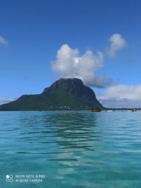 Scenic view of sea and mountains against blue sky