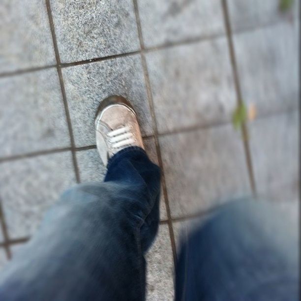 low section, shoe, person, personal perspective, standing, jeans, footwear, human foot, lifestyles, high angle view, men, unrecognizable person, leisure activity, street, canvas shoe, day, outdoors