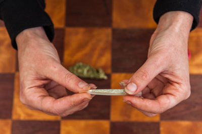 Cropped hand of woman holding marijuana joint