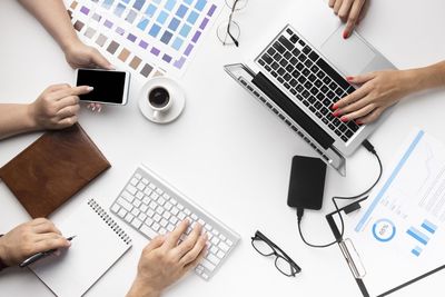 Cropped hands of woman using laptop on table