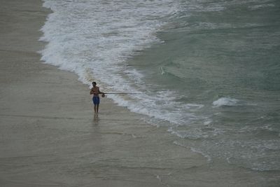 Rear view of man standing on beach