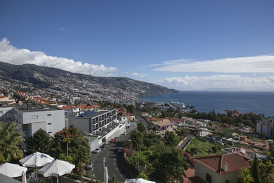 High angle view of townscape by sea against sky