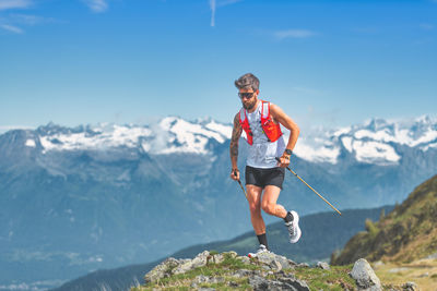 Mountain athlete with poles trains in the alps