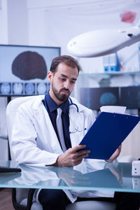 Portrait of businessman using mobile phone while standing in office