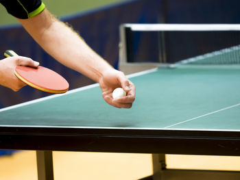 Cropped hands of man playing table tennis