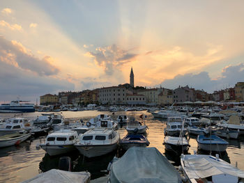 Boats moored at harbor during sunset