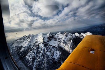 Aerial view of mountains against sky during winter