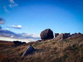 Rock formations on landscape against blue sky