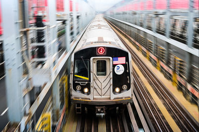 Metro train over railroad tracks