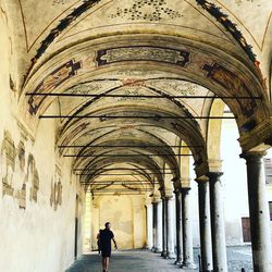 Full length rear view of man walking in historic building