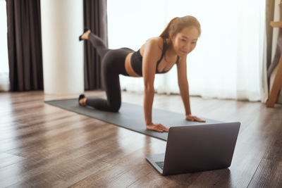 Side view of woman exercising in gym